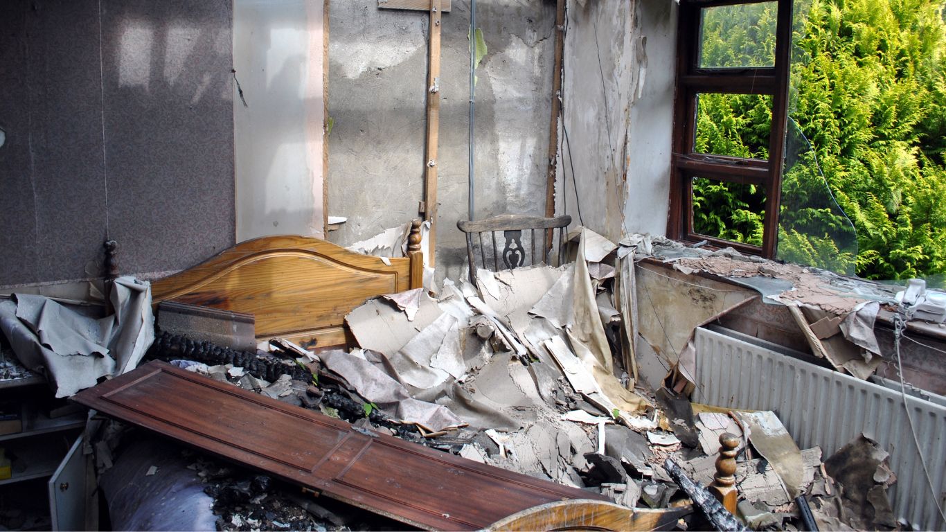 Heavily damaged bedroom interior after a house fire awaiting fire damage restoration in New Haven.
