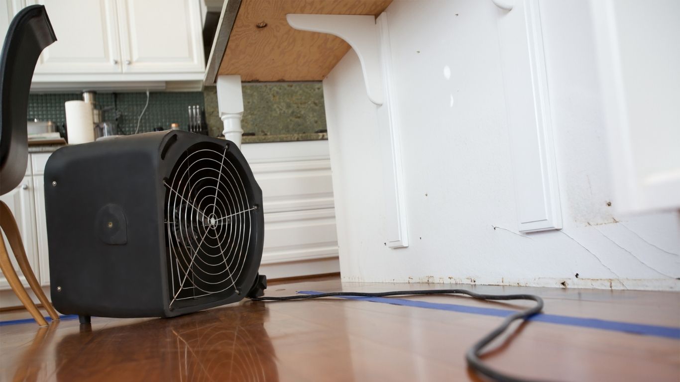 When Water Strikes Call Emergency Water Damage Restoration in Nashville Fast Fan used for emergency water damage restoration in a home with visible wall and floor damage in Nashville.